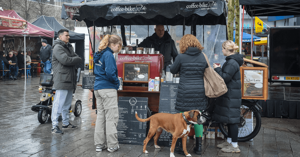 Markt bezoekers bij marktkraam coffee-bike op de Enschedese markt.